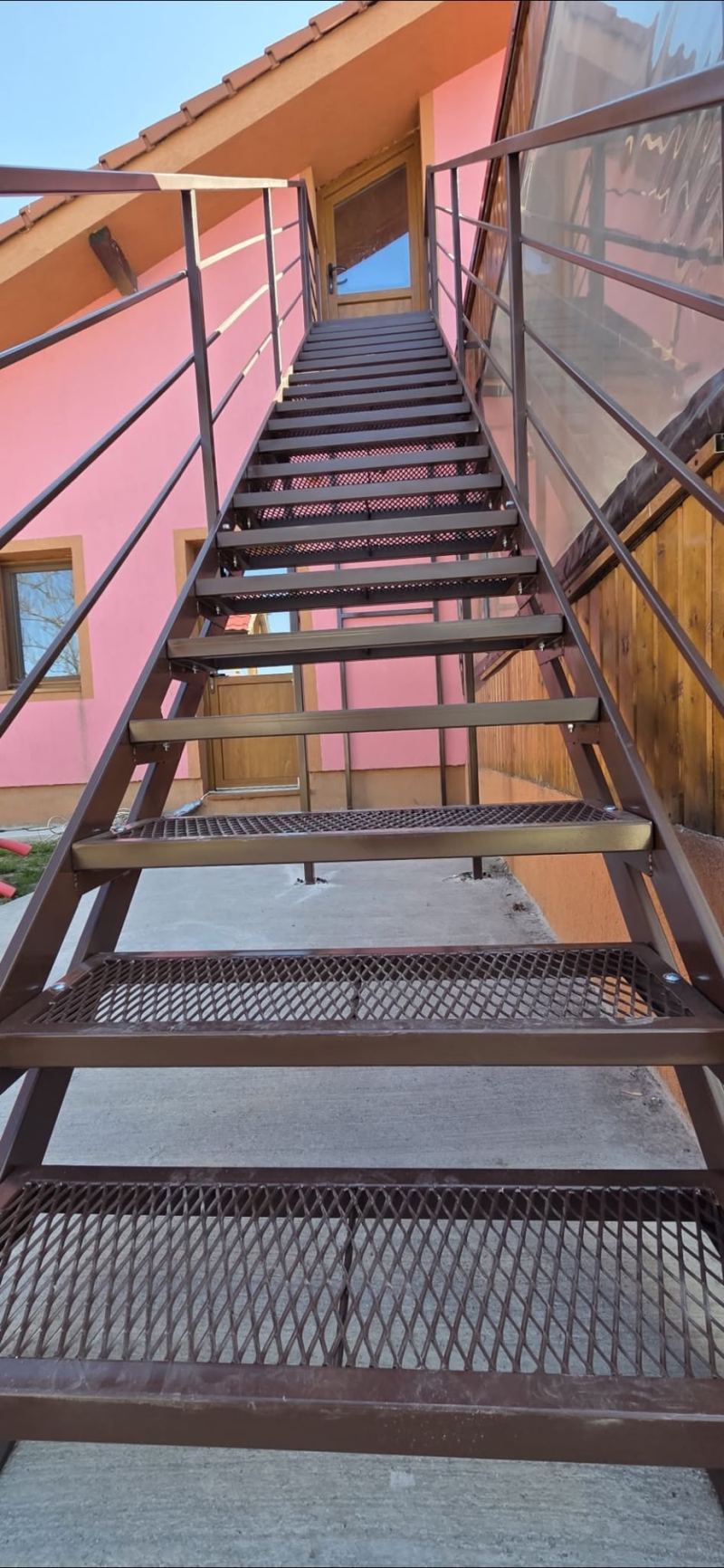 Scară metalică exterioară cu podest pentru acces la etaj