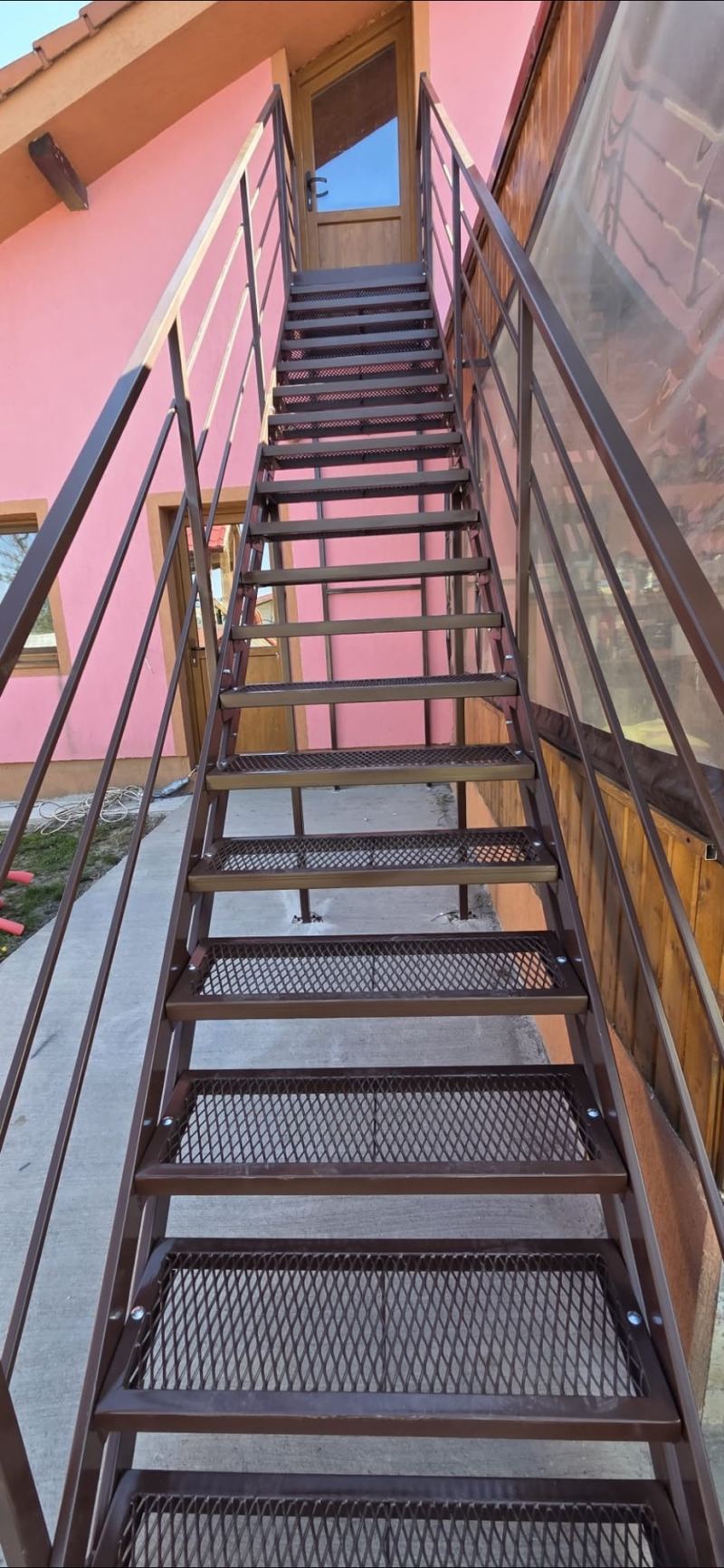 Scară metalică exterioară cu podest pentru acces la etaj
